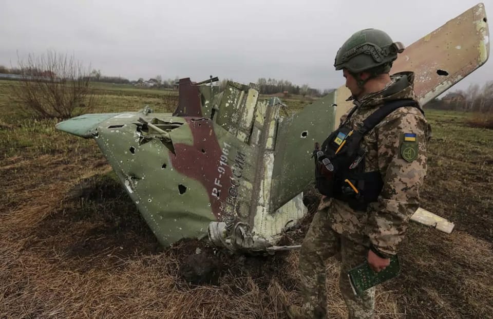 Український воїн біля уламків збитого російського бойового літака