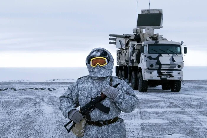 Российский солдат с автоматом возле военной техники в Арктике