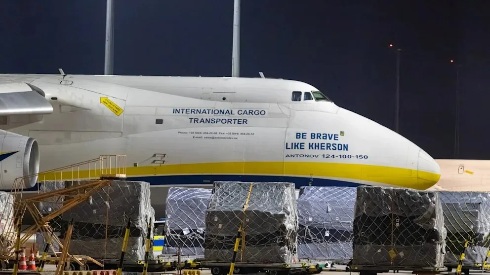 Білий Антонов-124 з написом Be Brave Like Kherson біля вантажу вночі