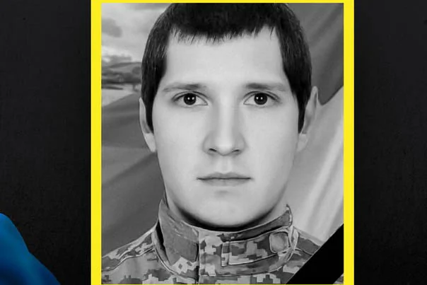 Чорно-білий портрет солдата в піксельній формі на тлі прапора в жовтій рамці