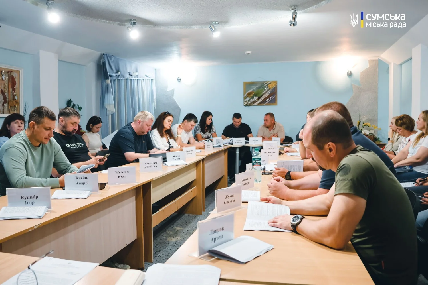 Учасники засідання сидять за столами з іменними табличками в залі Сумської міськради