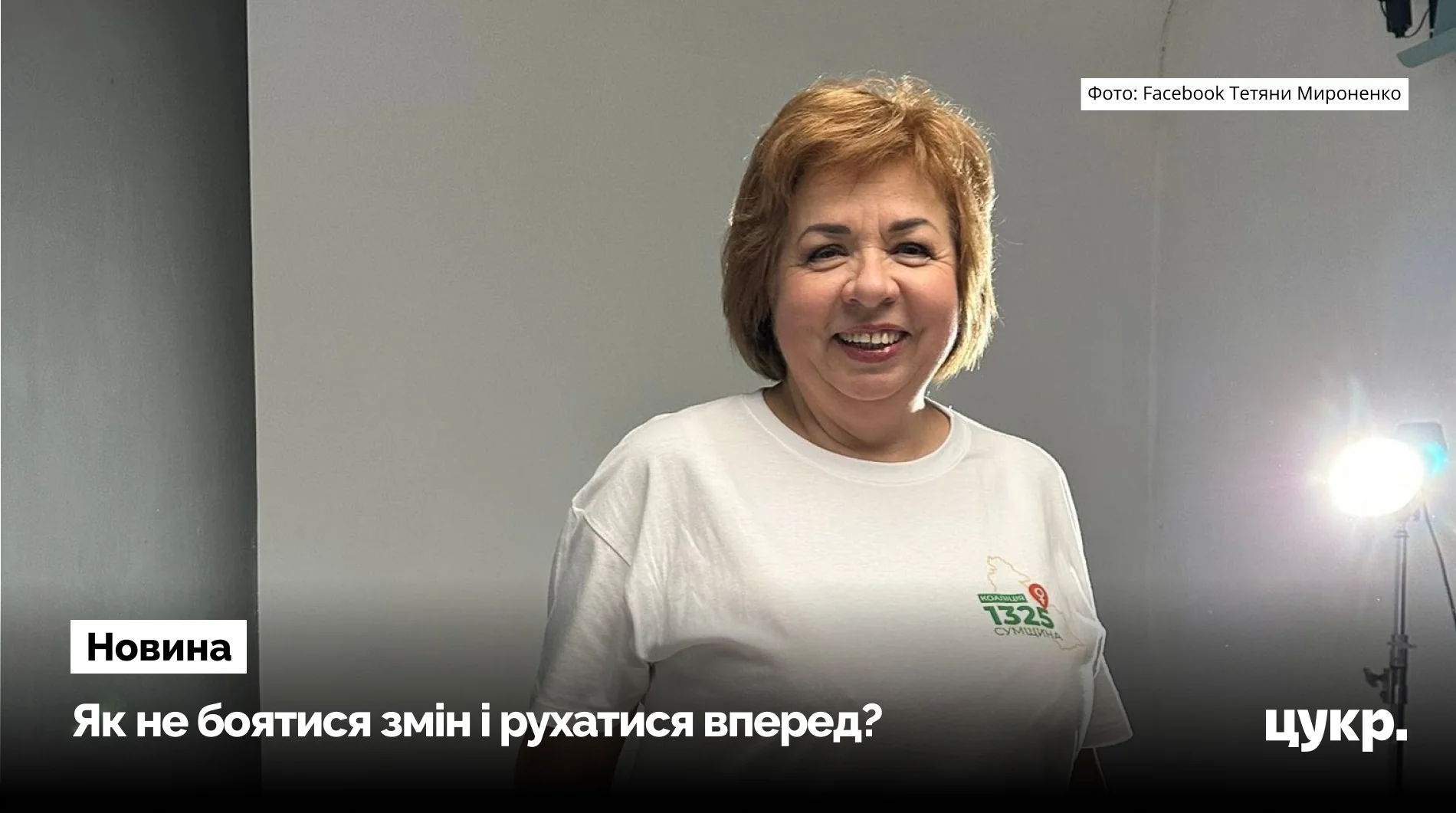 Тетяна Мироненко у білій футболці з логотипом Коаліція 1325 Сумщина посміхається в студії