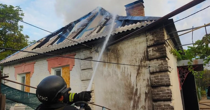 Рятувальник ДСНС гасить водою пошкоджений дах житлового будинку