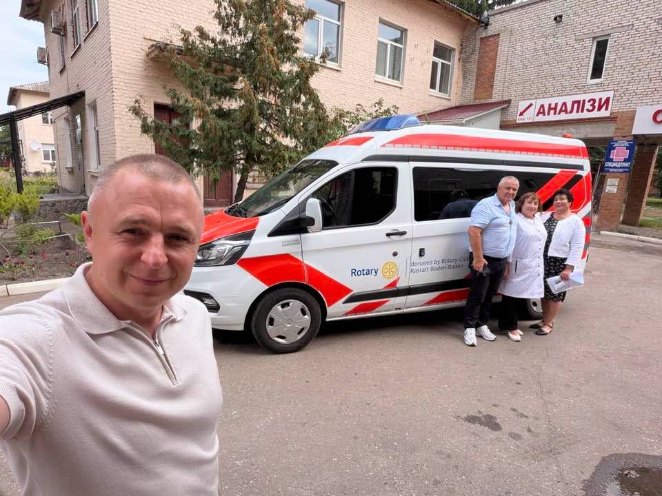 Чоловік робить селфі біля швидкої Rotary та трьох медиків біля поліклініки